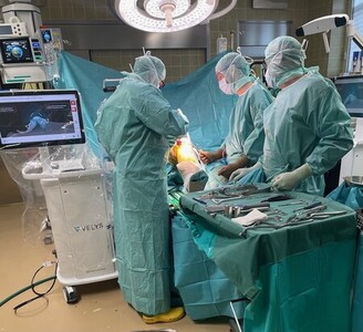 Prim. Prof DDr. Reinhold Ortmaier (vorne links) und OA Dr. Conrad Anderl (hinten rechts) bei einer Operation mit dem „Velys“ (links)