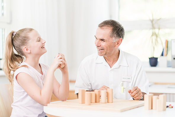 Das Bild zeigt einen Kinderarzt und ein Kind.