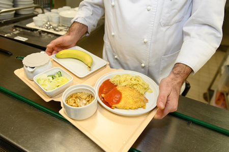 Das Essen wird auf den geteilten Tabletts verteilt. 