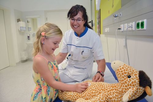 Das Bild zeigt eine Pflegerin und ein Kind bei einer Diabetesschulung.