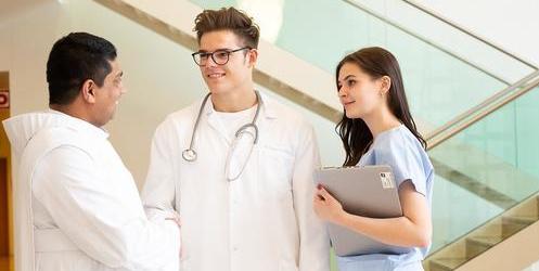 Das Bild zeigt einen Ordensbruder im Gespräch mit Krankenhauspersonal